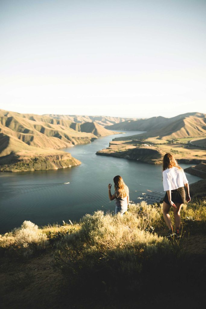 Above it all, together. Two women pause in the quiet vastness of Iceland — where fjords meet sky and stillness feels like freedom. Here, connection comes naturally: to nature, to each other, to yourself.